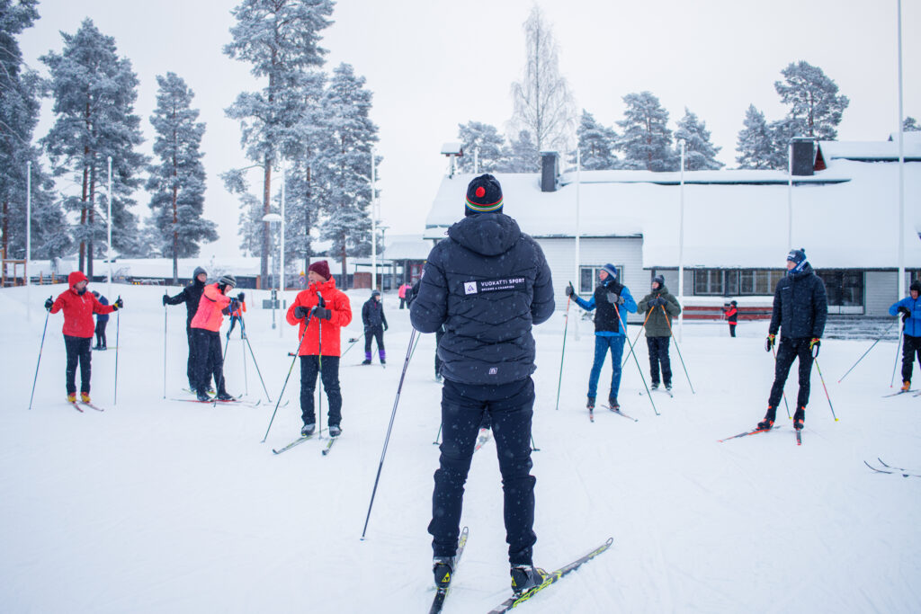 Eläkeläiset hiihtokurssilla ohjaajan kanssa